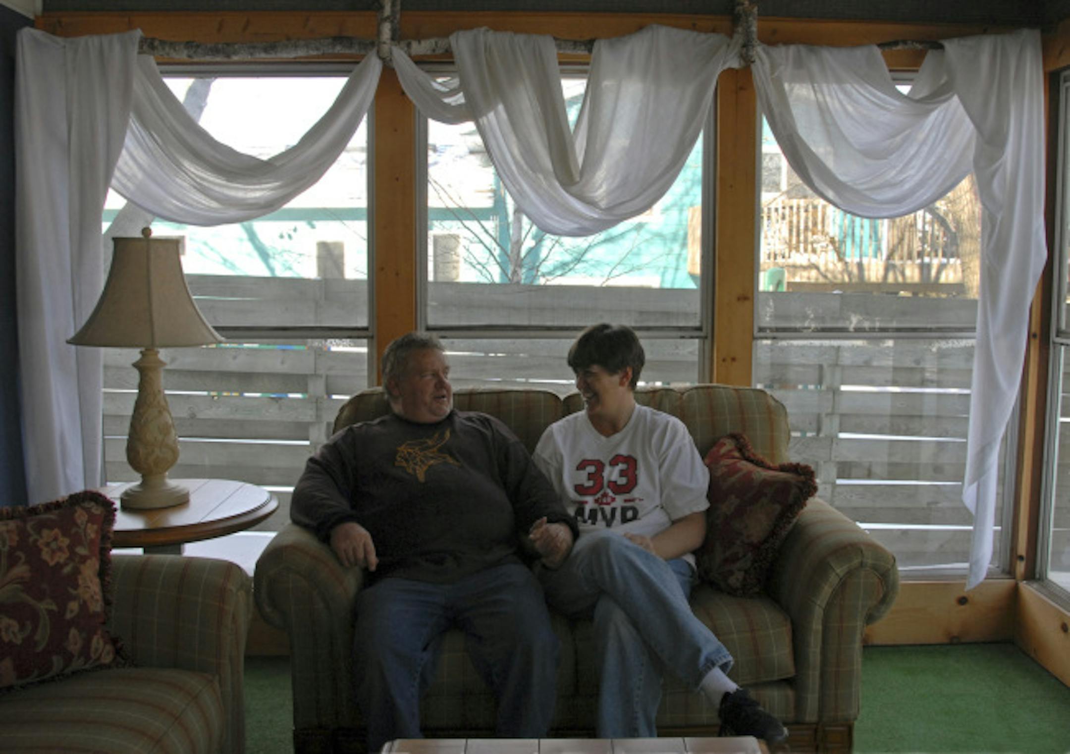 John and Sheryl Martin sat on the enclosed porch of their home. After getting help through a counseling program, they paid off $35,000 in debts.
