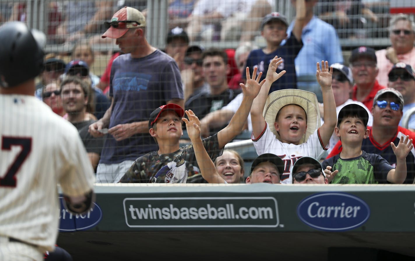 Young fans keep their eyes on a ball that Joe Mauer threw into the stands during the game.