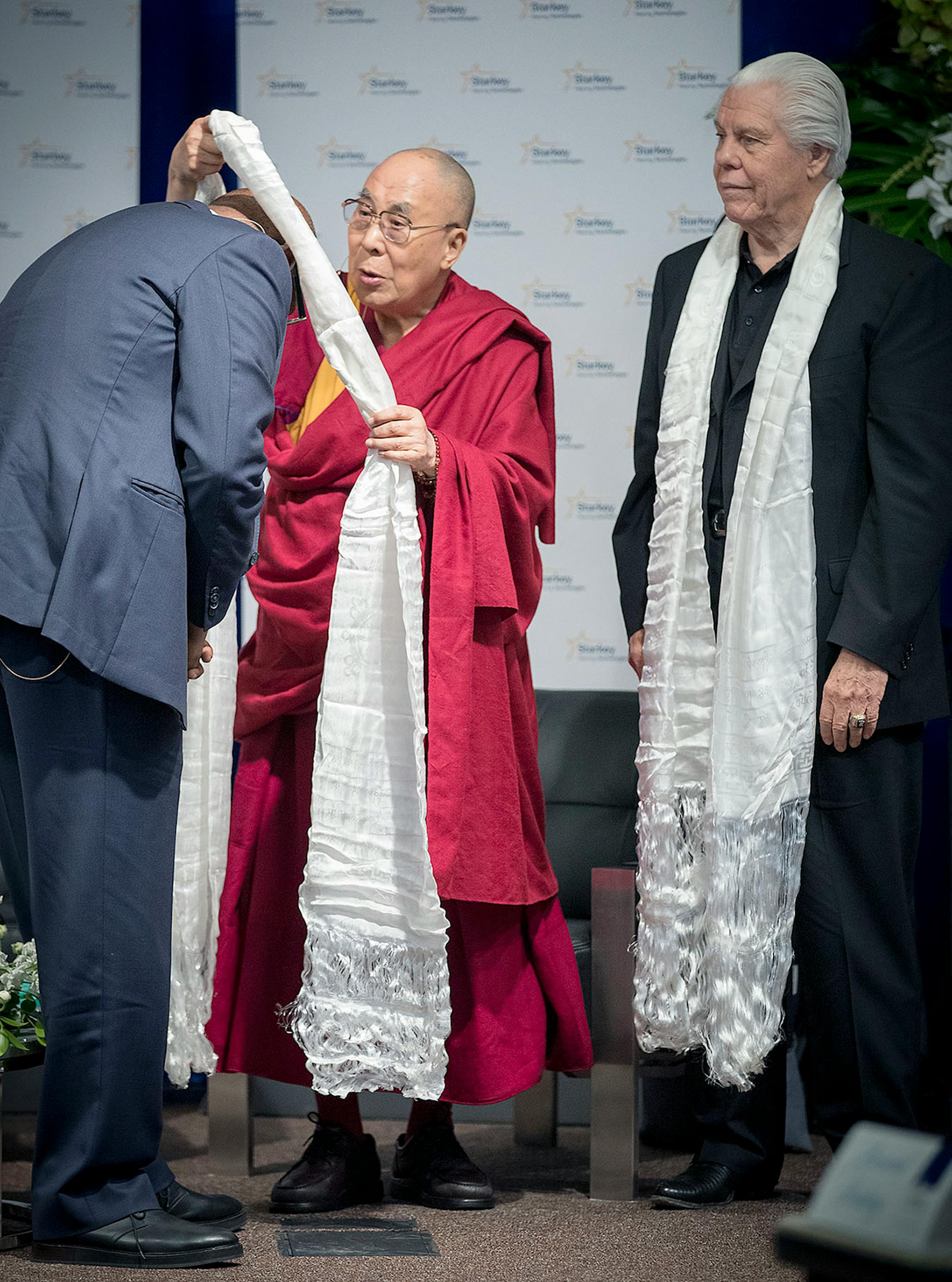 The Dalai Lama presented actor Forest Whitaker, left, and Starkey Hearing Technologies Owner, CEO, and President Bill Austin with a gift after they participated in a panel discussion at Starkey Hearing Technologies, Friday, June 23, 2017 in Eden Prairie, MN.