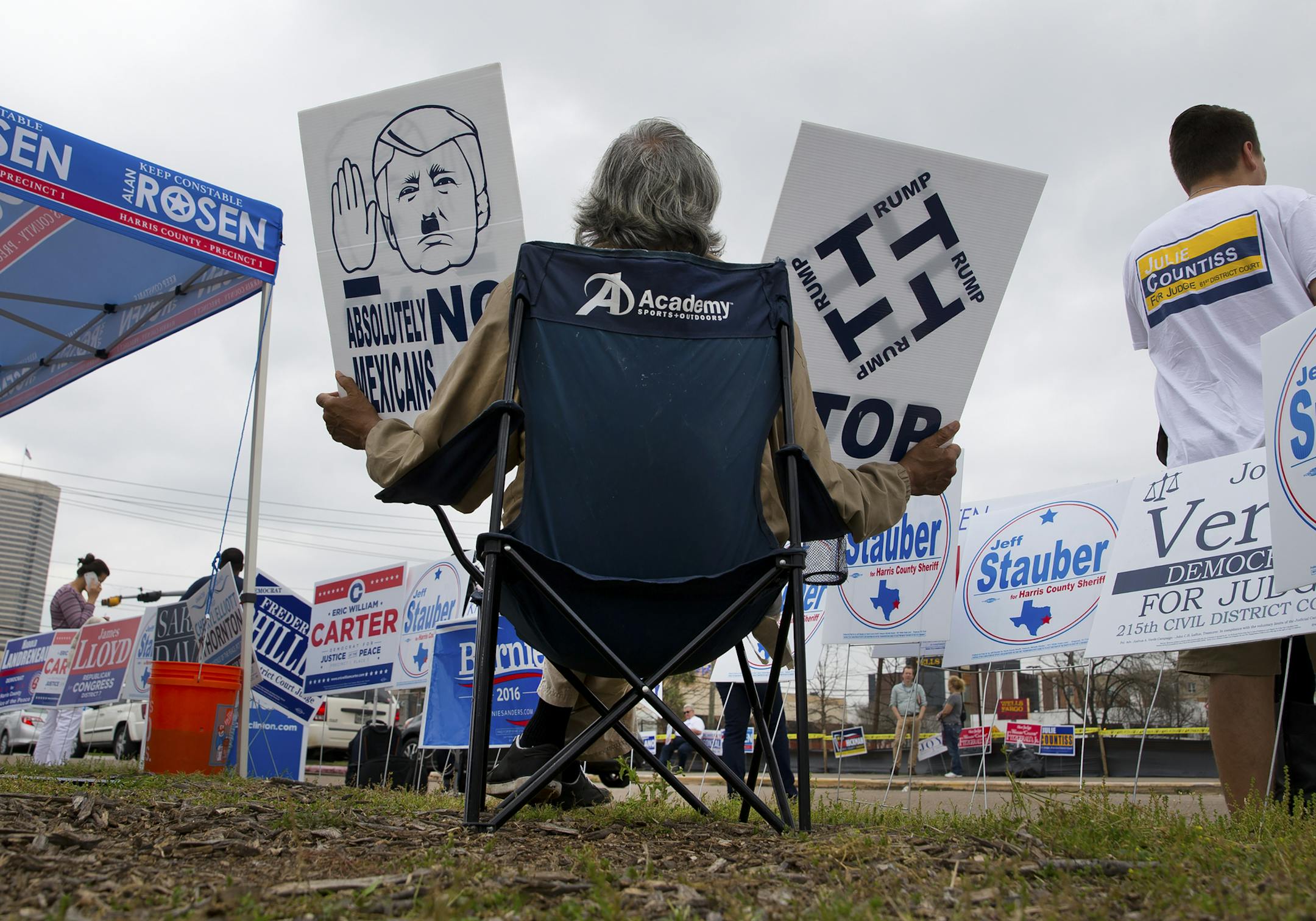 Outside the West Gray Community Center polling station on Super Tuesday, Francisco Valle holds anti-Trump signs, one depicting him as Hitler and another that arranges his name into a swastika-like design, in Houston, March 1, 2016. (Stephen Crowley/The New York Times)