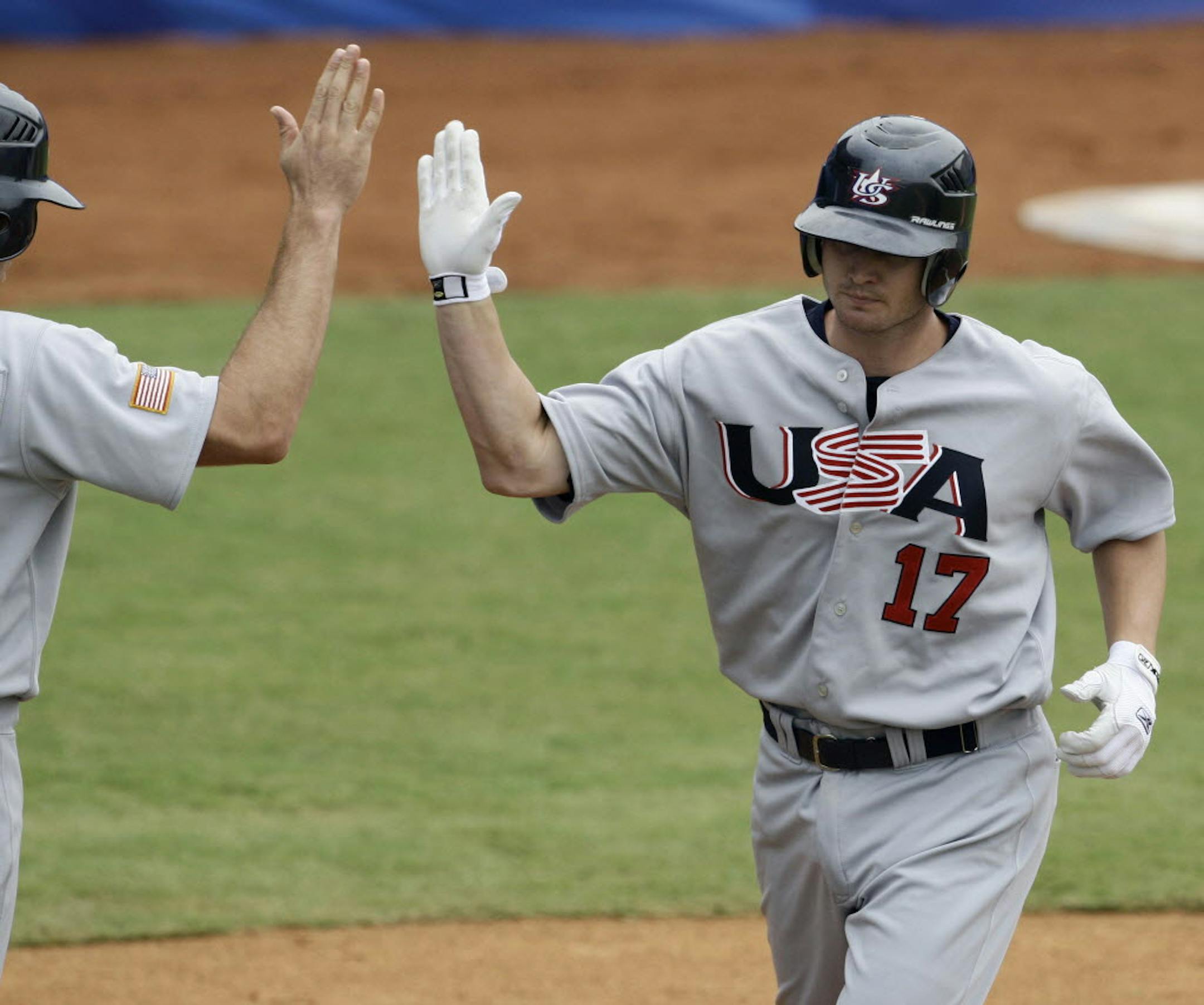 USA's Matt Brown, right, is congratulated by right fielder Nate Schuerholtz after hitting a second inninng solo home run against the Netherlands during their baseball game Thursday.