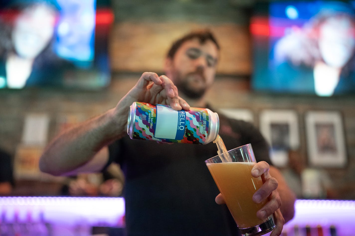 Nick Herrera, a bartender at The Saloon, poured a "Hello my pronouns are" beer by Modist Brewing Co. The Saloon bar announced it cut ties with Bud Light Monday June 20,2023 in Minneapolis,Minn.] JERRY HOLT • jerry.holt@startribune.com