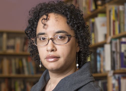 photo of author Shannon Gibney, with bookshelves in the background