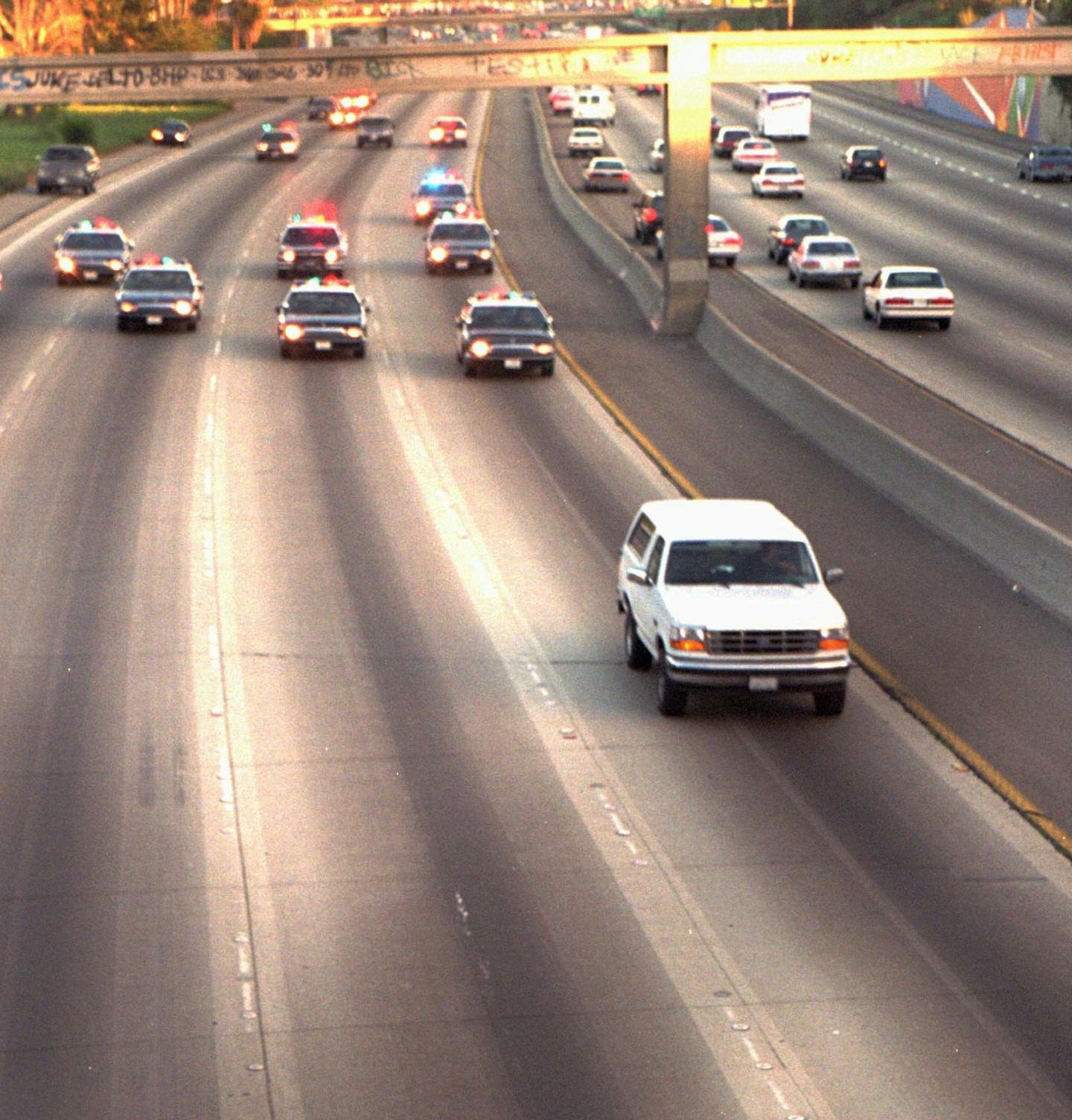 A white Ford Bronco, driven by Al Cowlings and carrying O.J. Simpson, is trailed by police cars as it travels on a southern California freeway on June 17, 1994, in Los Angeles. Cowlings and Simpson led authorities on a chase after Simpson was charged with two counts of murder in the deaths of his ex-wife and her friend.