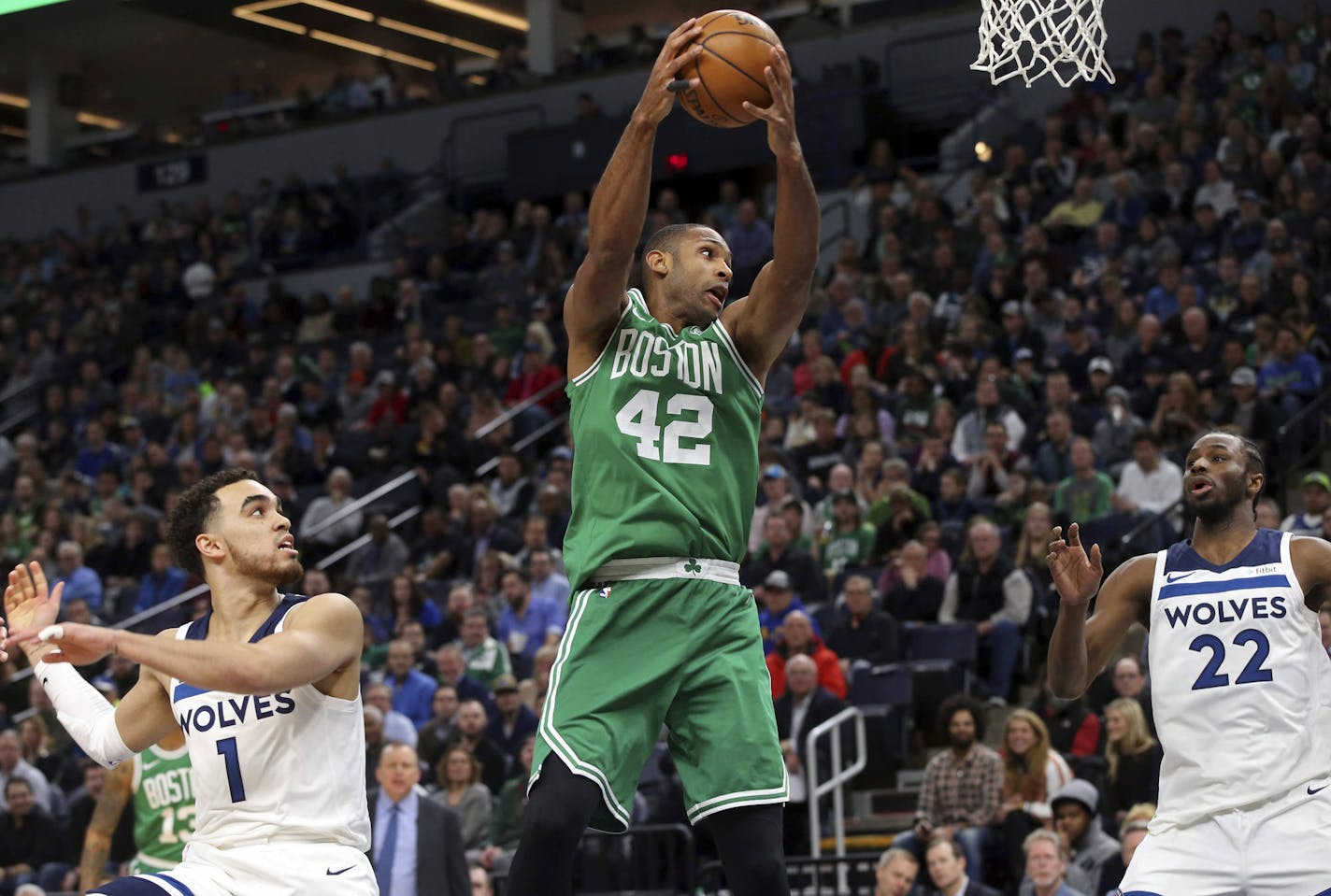 Boston Celtics's Al Horford, center, of Dominican Republic, pulls in a rebound as Minnesota Timberwolves' Tyus Jones, left, and Andrew Wiggins, right, watch in the first half of an NBA basketball game Thursday, March 8, 2018, in St. Paul, Minn. (AP Photo/Jim Mone)