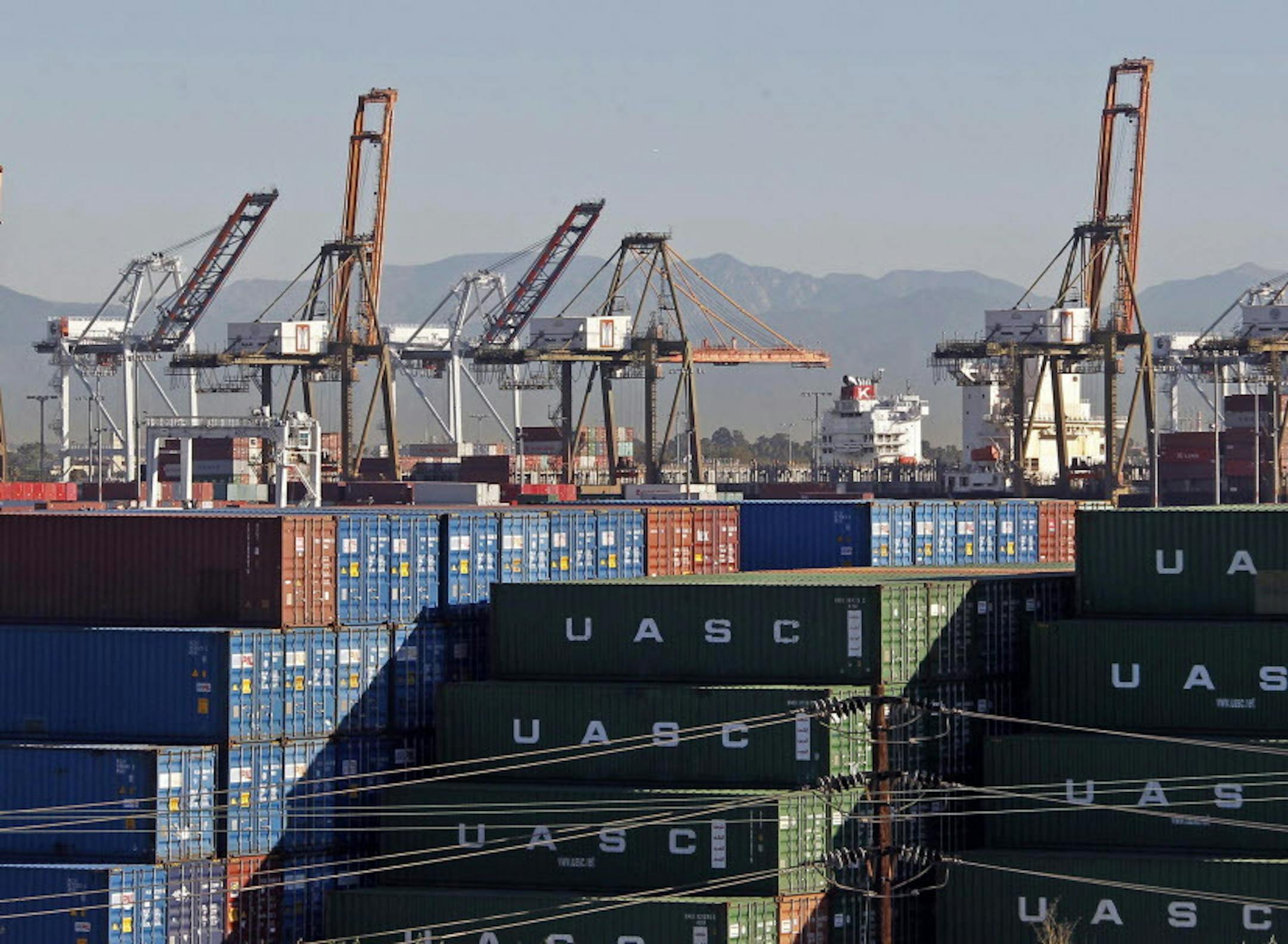 The Ports of Los Angeles and Long Beach, with some cargo loading cranes in the upright and idle position, are seen in this view from the San Pedro area of Los Angeles, Thursday, Feb. 12, 2015. Seaports in major West Coast cities that normally are abuzz with the sound of commerce are falling unusually quiet. Companies that operate marine terminals said they weren't calling workers to unload ships Thursday that carry car parts, furniture, clothing, electronics ó just about anything made in As