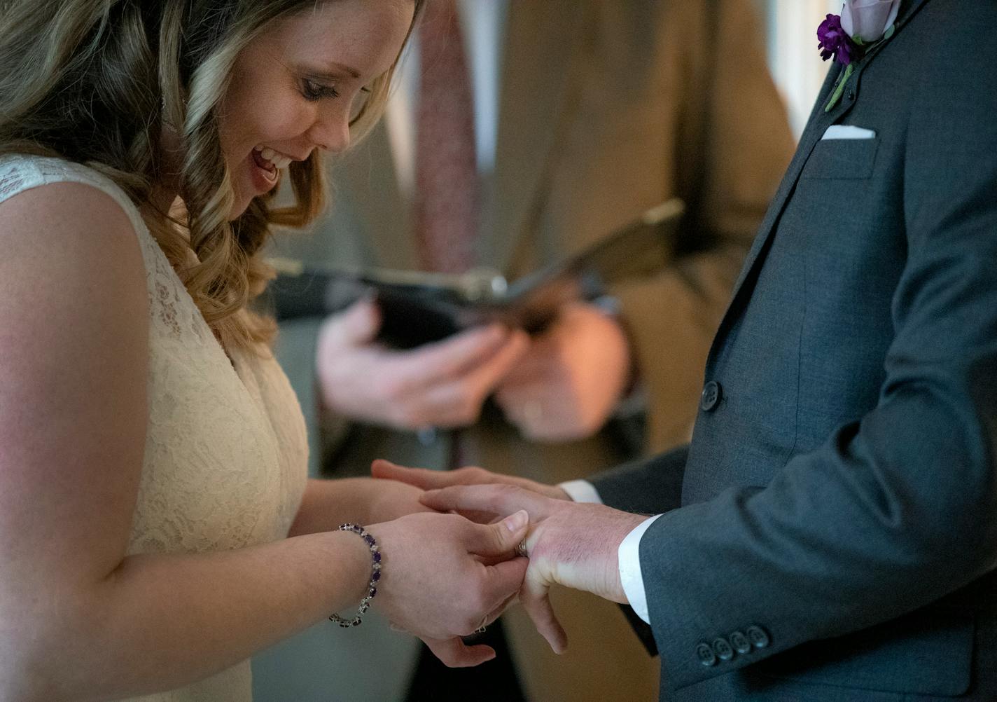 Bride Jamie and groom Ross Buchanan exchanged rings as they held their wedding in their living room in Roseville. ] CARLOS GONZALEZ • cgonzalez@startribune.com – Roseville, MN – March 18, 2020, Living room Wedding of Ross and Jamie Buchanan -- Coronavirus (COVID-19)