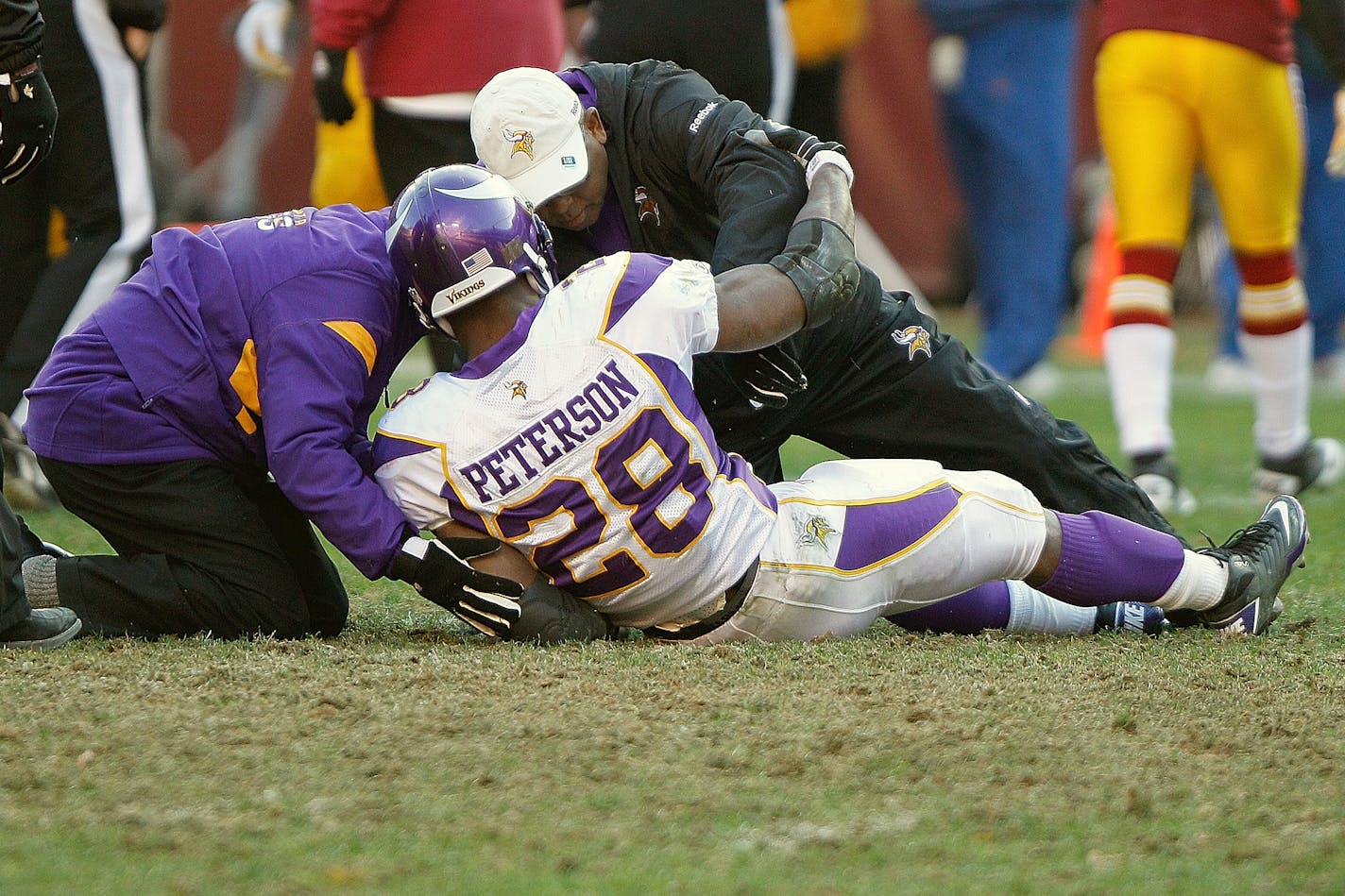 Minnesota Vikings running back Adrian Peterson (28) is helped up after an injury during the second half of an NFL football game against the Washington Redskins in Landover, Md., Saturday, Dec. 24, 2011. (AP Photo/Evan Vucci) ORG XMIT: NYEOTK