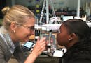 Optometrist Dr. Meredith Walburg examines Denae Whitfield's eyes at Harding High School. Whitfield is one of 2,500 St. Paul Public Schools students sc