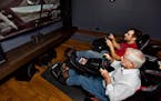 Matt Wagoner, in red shirt, of Limitless Construction, and friend Tom Sweeney try out the NASCAR simulator that Wagoner installed in the theater of a 