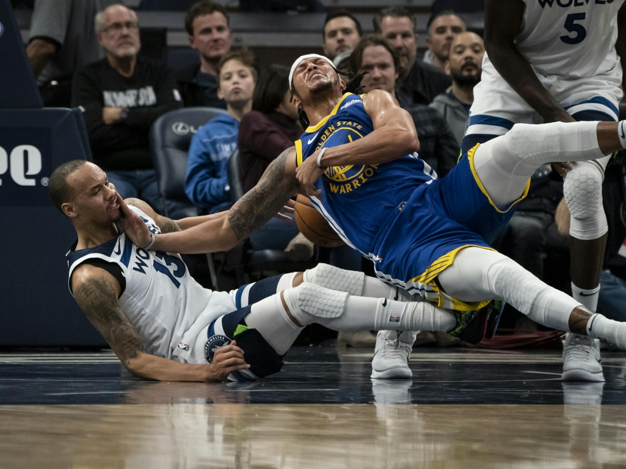 Minnesota Timberwolves guard Shabazz Napier (13) and Golden State Warriors guard Damion Lee (1) tumbled to the ground after a collision that led to Napier fouling in the first half.