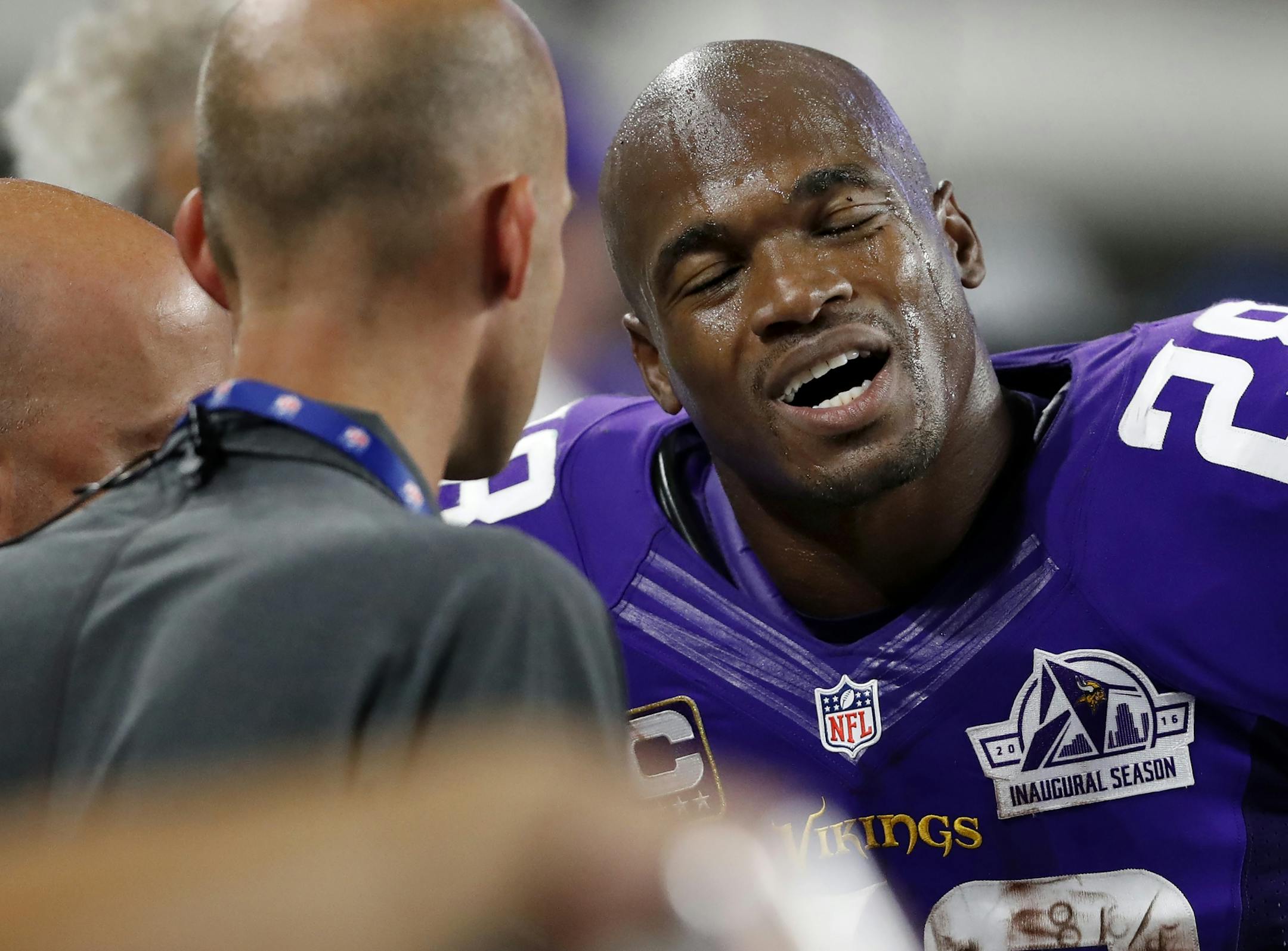 Minnesota Vikings running back Adrian Peterson (28) spoke with trainers on the sideline in the third quarter after leaving the game.