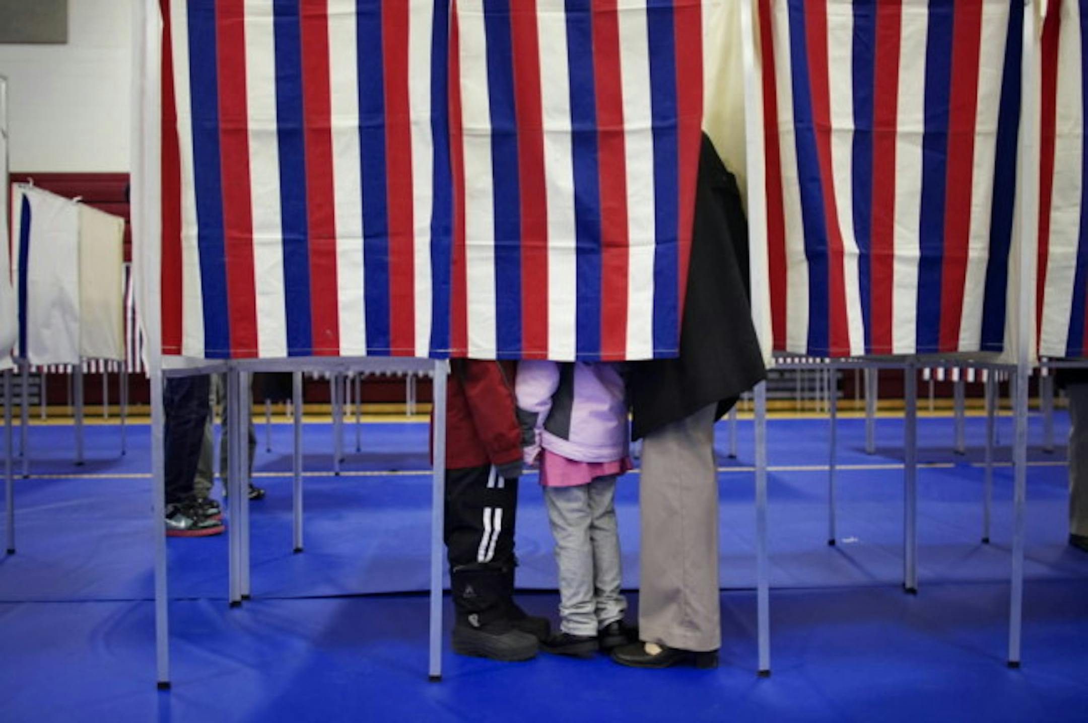Stephanie Sledjeski stands inside a voting booth with her children Rachel, 5, and Ryan, 7, at Bedford, N.H., High School.