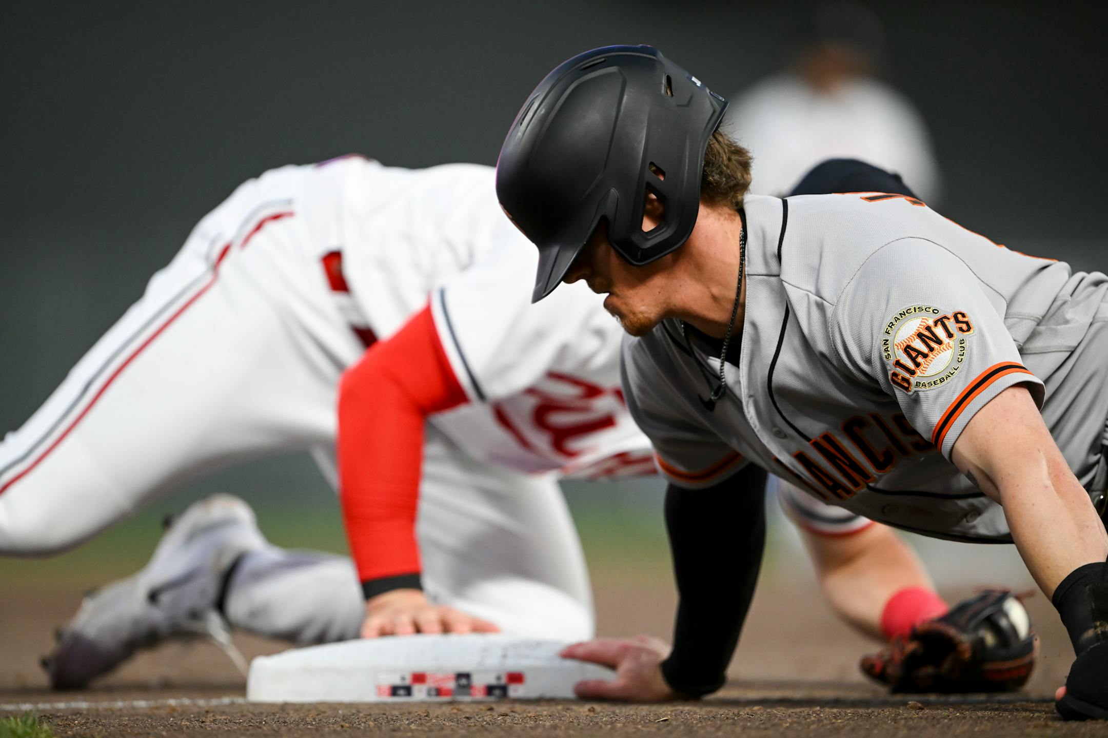 San Francisco Giants pinch runner Bryce Johnson tags back to third after overrunning the base after a single hit by third baseman Casey Schmitt.