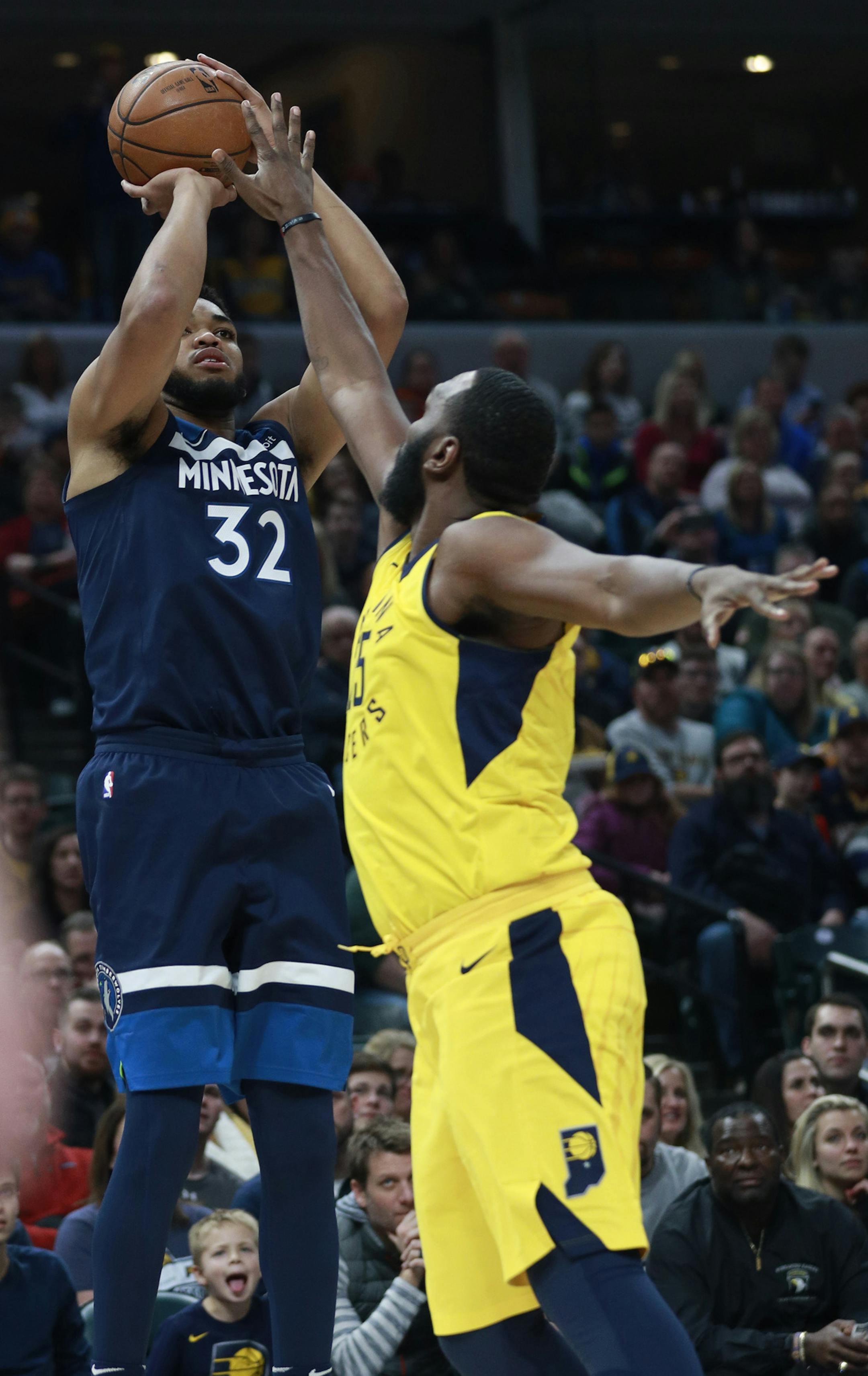 Minnesota Timberwolves center Karl-Anthony Towns (32) shoots while defended by Indiana Pacers center Al Jefferson in the first half of an NBA basketball game, Sunday, Dec. 31, 2017, in Indianapolis. (AP Photo/R Brent Smith)