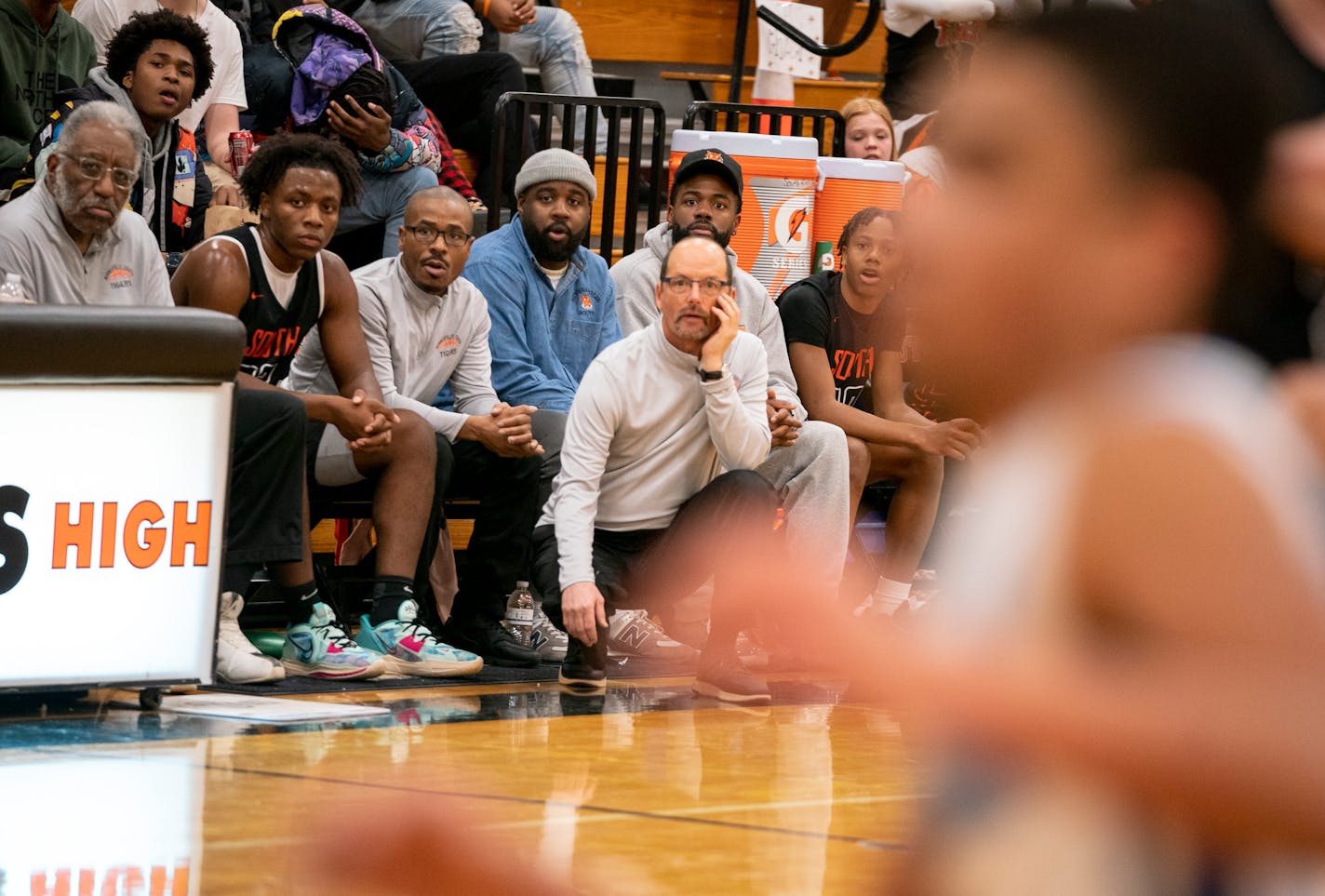 Coach Joe Hyser, with his team and coaches, kept an eye on the progress of the Minneapolis South boys basketball team. Eight players transferred from South during the offseason.