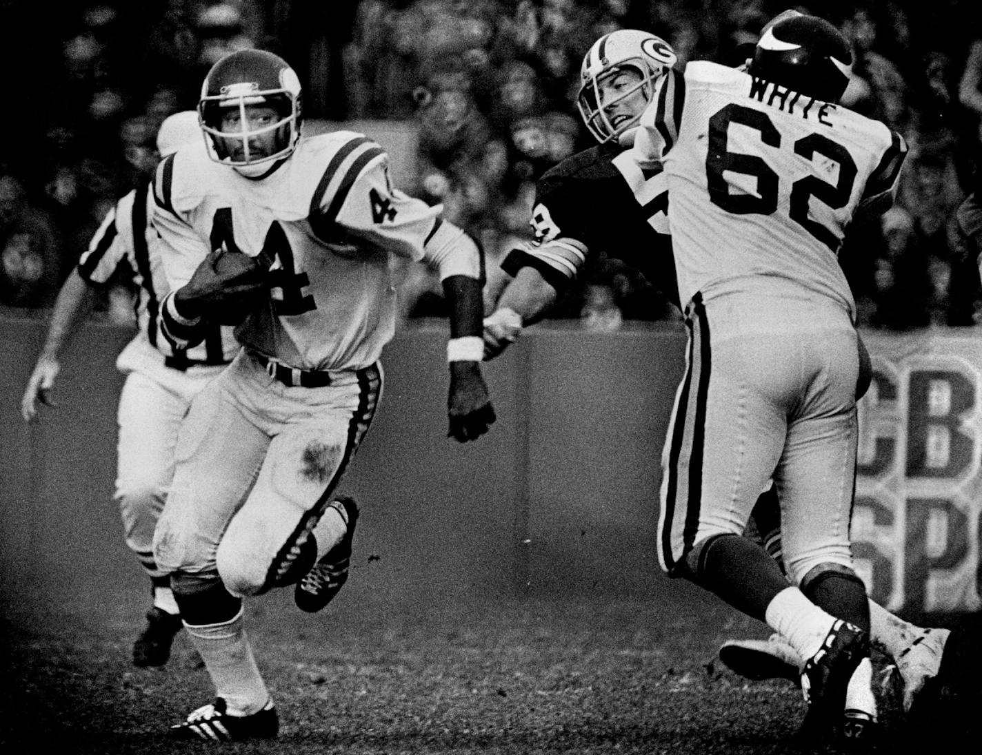 Behind Ed White's blockk (62) on Green Bay linebacker Tom Toner, running back Chuck Foreman (44) found daylight in the Packer defense during a game on November 3, 1975.