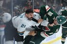 San Jose Sharks defenseman Jacob Middleton (21) and Minnesota Wild left wing Jordan Greenway (18) fight in the first period Tuesday, Nov. 16, 2021 at 