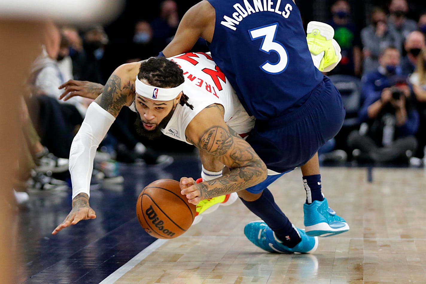 Toronto Raptors guard Gary Trent Jr. (33) is fouled by Minnesota Timberwolves forward Jaden McDaniels (3) during the second half of an NBA basketball game Wednesday, Feb. 16, 2022, in Minneapolis. (AP Photo/Andy Clayton-King)