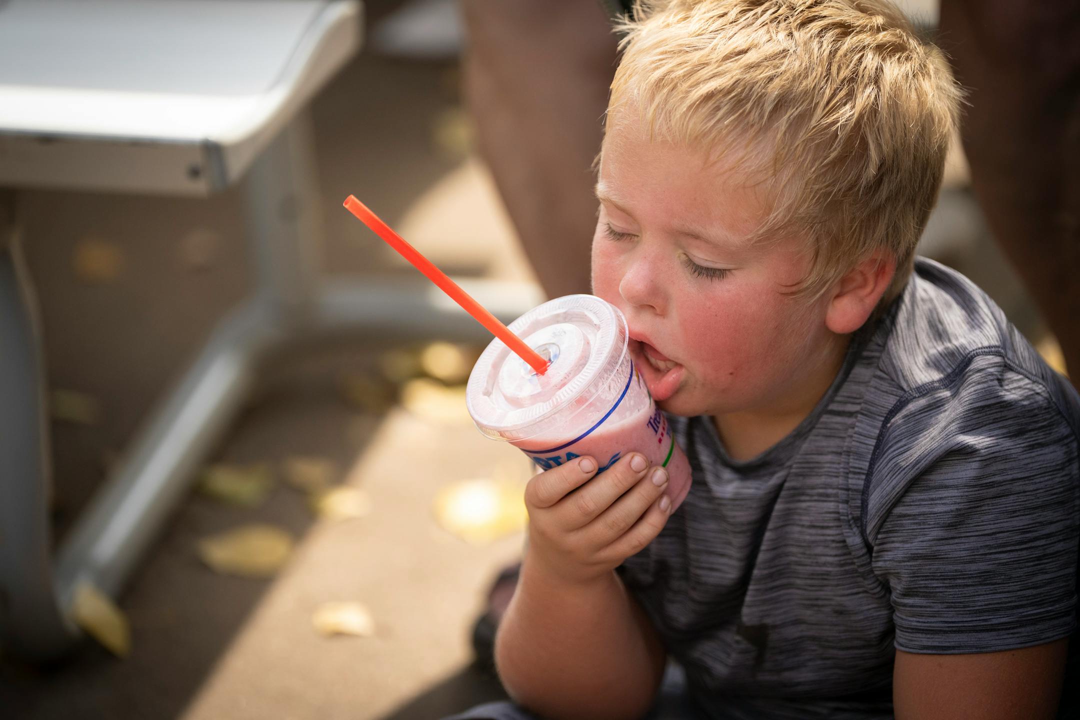 Eight-year-old J.J. (no lastname) cools off with a smoothie to the cheek on the first day of the Minnesota State Fair on Thursday, Aug. 24, 2023 in Falcon Heights, Minn.