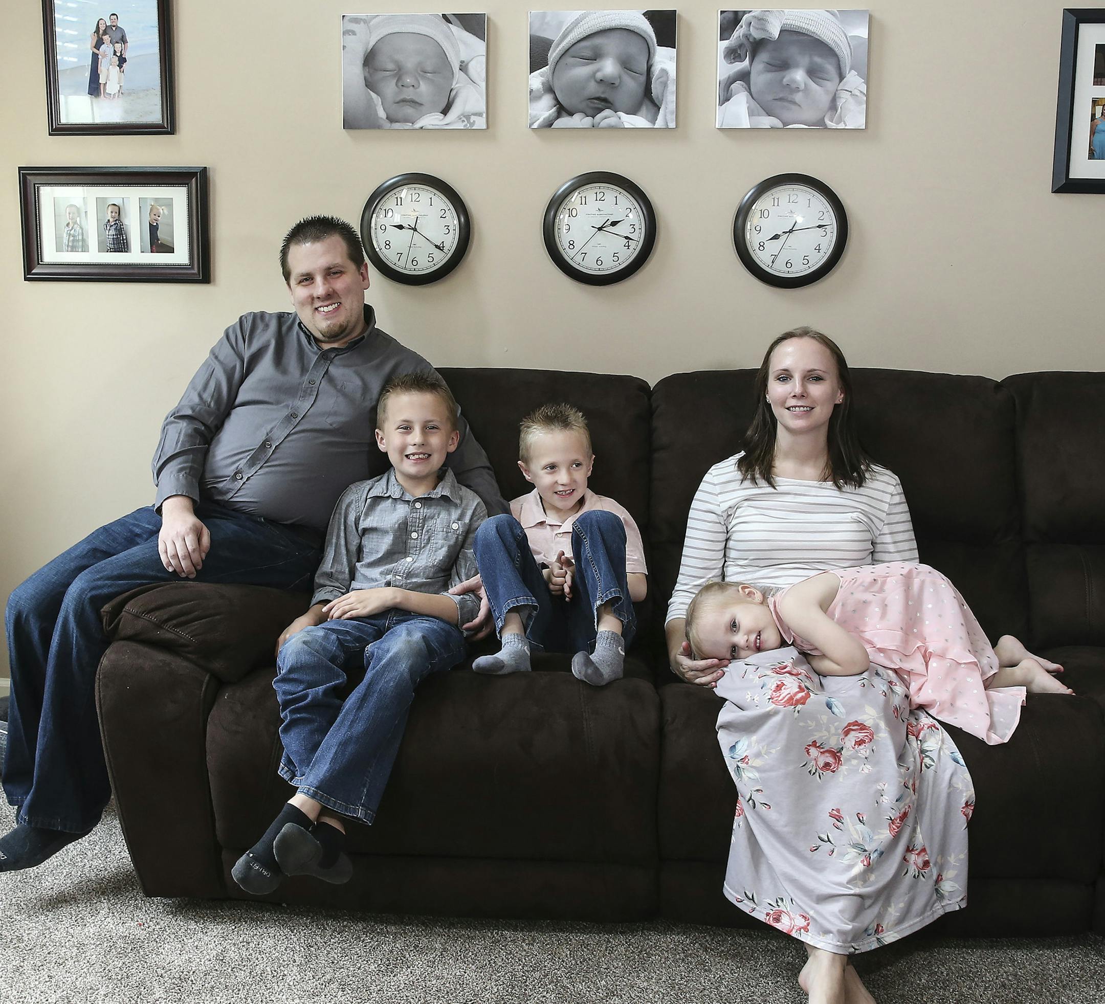 Heather Bankos, 31, of Macungie donated her uterus through a uterine transplant clinical trial at Baylor University Medical Center. From left, Brendon Bankos, Nathan, 8, Matthew, 6 Ellie, 3, and Heather sitting under photos of their kids in the order and time they were born, on Friday, May 31, 2019. (Steven M. Falk/Philadelphia Inquirer/TNS)