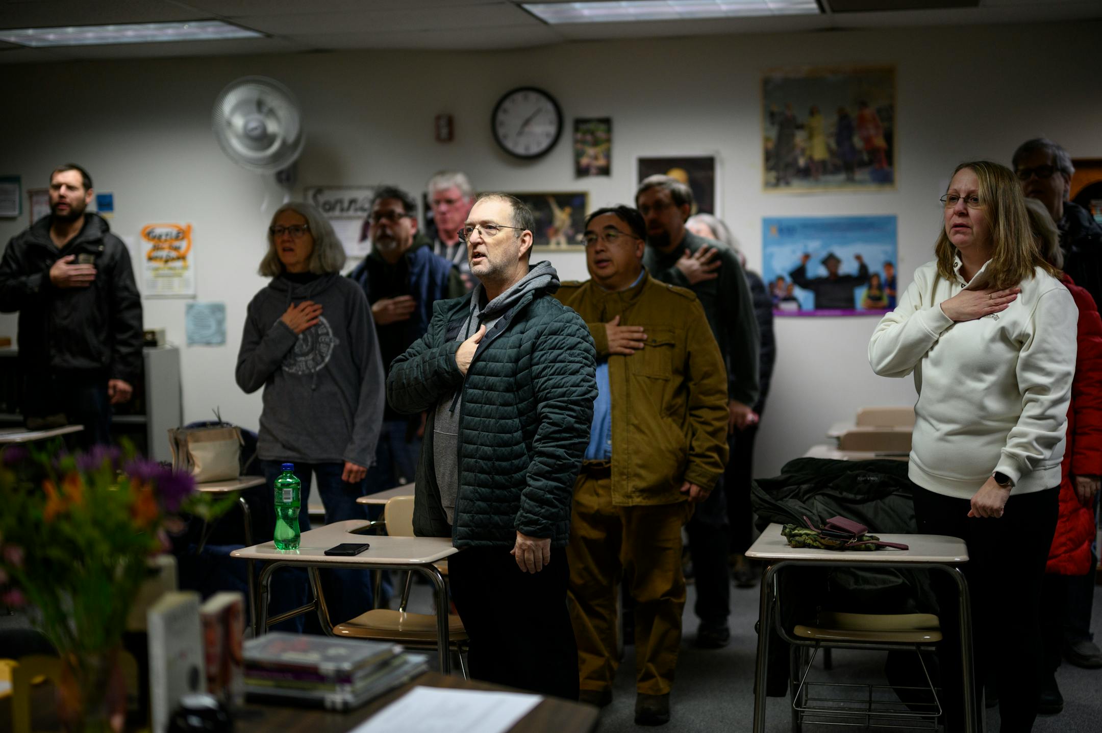 Caucus goers recite the Pledge of Allegiance before the start of a GOP Caucus Tuesday, Feb. 1, 2022 at White Bear Lake Area High School in White Bear Lake, Minn.