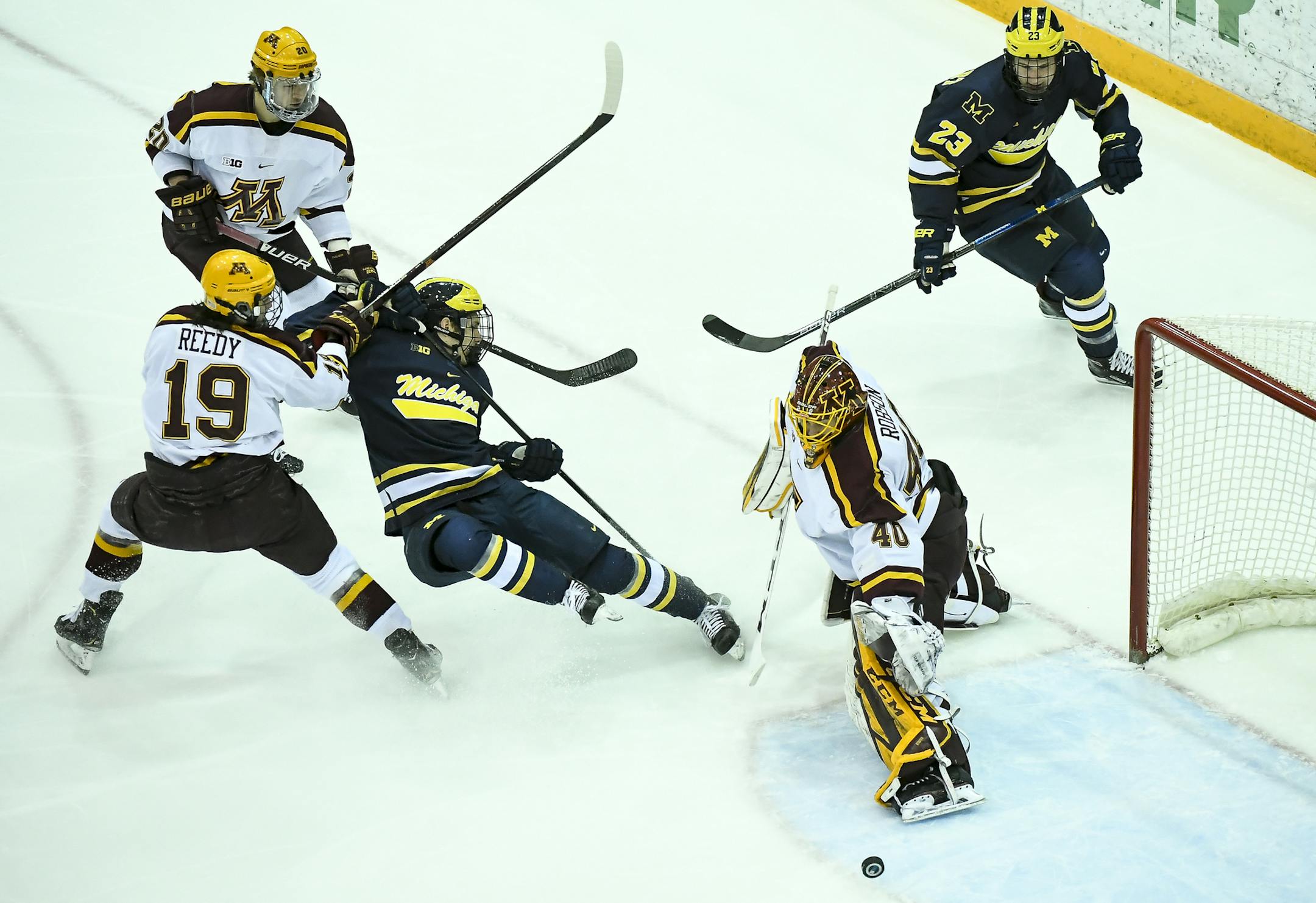 Michigan Wolverines forward Brendan Warren (11) was knocked off his skates while attacking Minnesota's goal against Minnesota Golden Gophers forward Scott Reedy (19) and goaltender Mat Robson (40) during the first period. ] Aaron Lavinsky ¥ aaron.lavinsky@startribune.com The University of Minnesota Golden Gophers men's hockey team played the Michigan Wolverines Friday, Feb. 1, 2019 at the 3M Arena at Mariucci in Minneapolis, Minn.