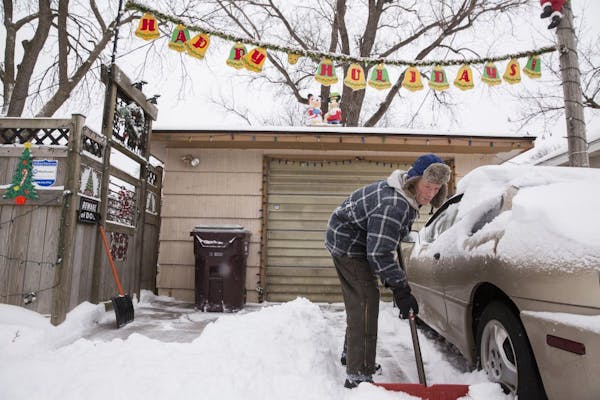 Chris Bowker clears his driveway of snow in St. Paul on Tuesday, December 29, 2015. "It's good to see the white stuff," said Bowker.