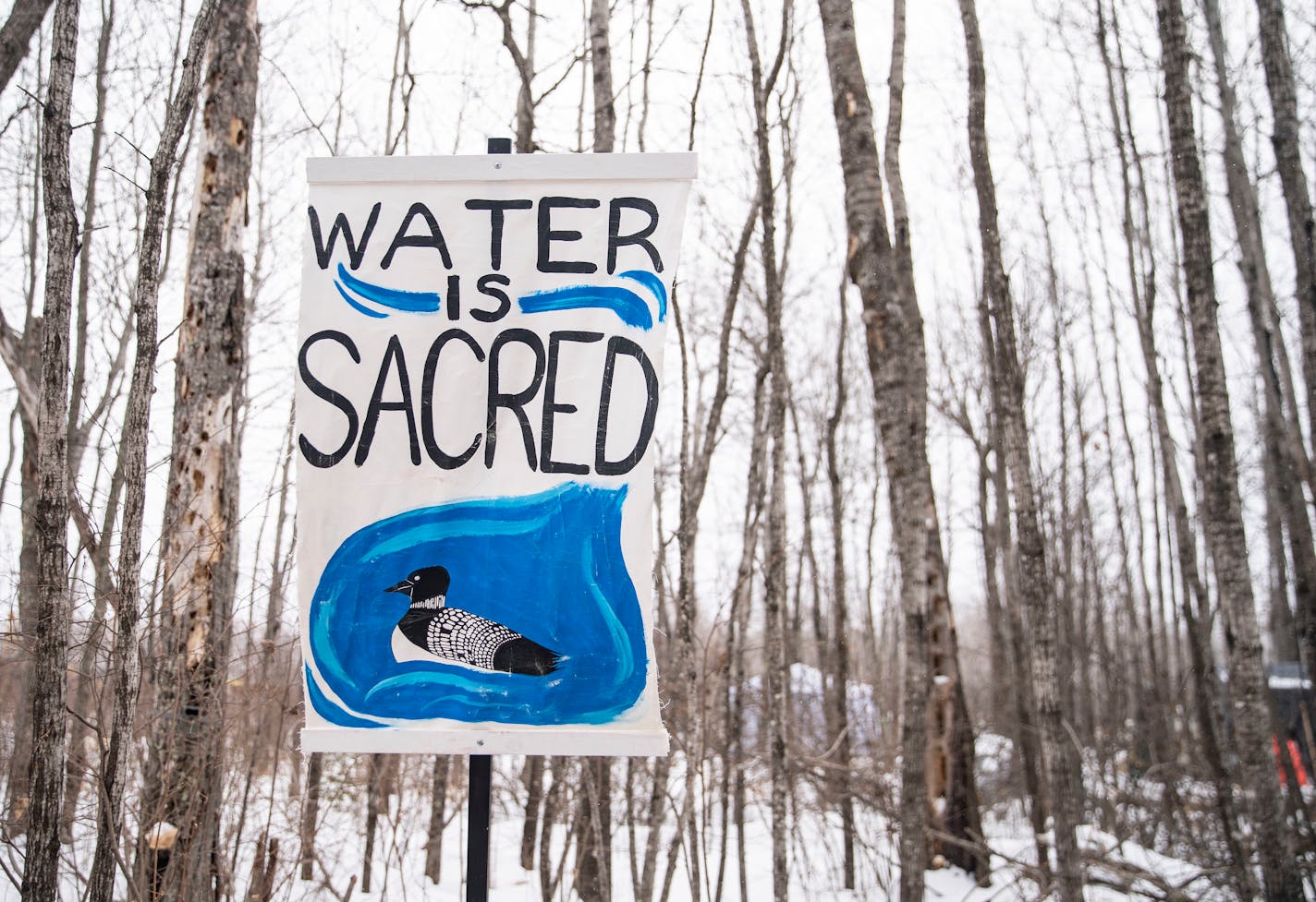 Signs are posted outside Camp Migizi, a small encampment of mostly indigenous water and land protectors located right beside the Enbridge Line 3 construction site on the Fond Du Lac Native American reservation in Cloquet, MN. ]