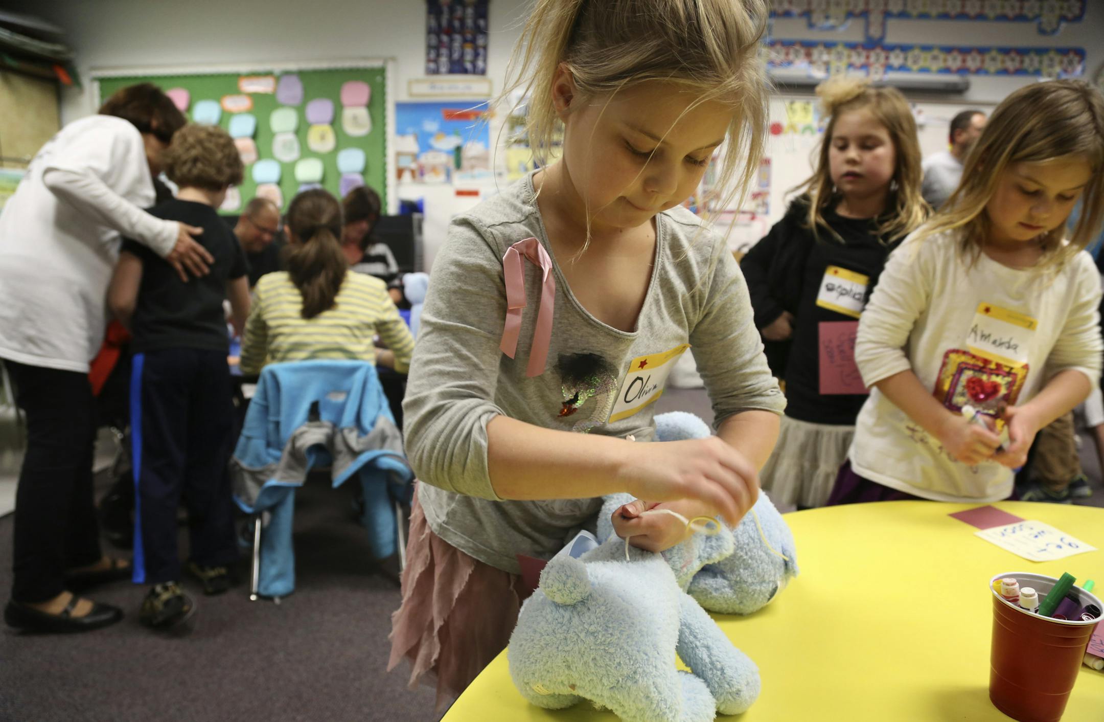 Olivia Zucker, 7, left, attached a get well card to one of the 200 stuffed animals as she and other volunteers wrote notes and attached them to stuffed animals for sick kids at tThe Children's Hospital during VOICE (Volunteer opportunities in the Community Service Experience) festivities at the Sabes Jewish Community Center Barry Family Campus in St. Louis Park, Min.,Tuesday, March 5, 2013. ] (KYNDELL HARKNESS/STAR TRIBUNE) kyndell.harkness@startribune.com