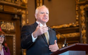 Gov. Tim Walz answers questions after a bill signing expanding support for service dogs in training at the State Capitol in St. Paul on May 8, 2025.
