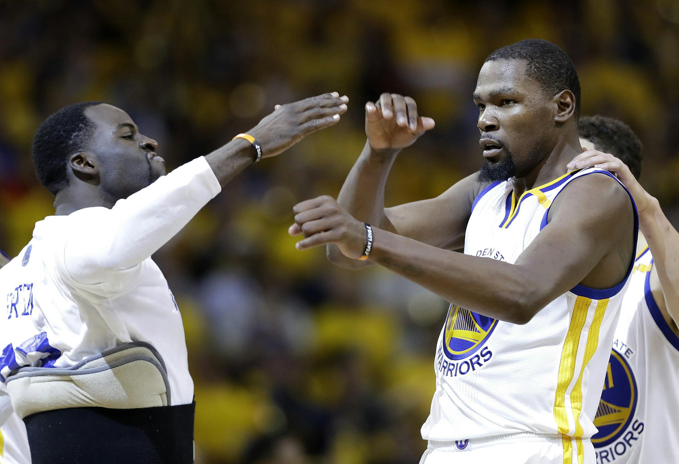 Kevin Durant, center, celebrated with Golden State teammates Draymond Green, left, and Klay Thompson.