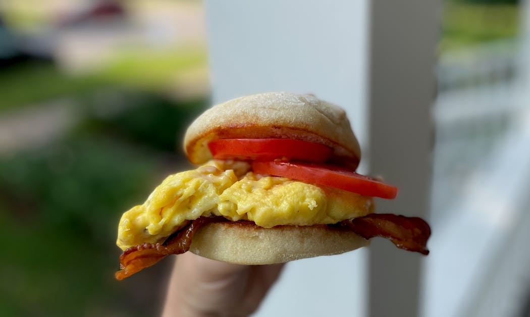 A thick cut tomato livens up this egg and bacon on a house-made English muffin.