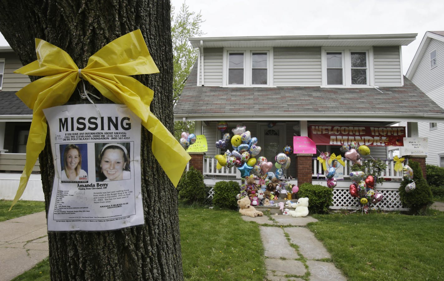 A missing poster still tied on a tree outside the Cleveland home of freed kidnap victim Amanda Berry on Wednesday.