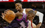 Minnesota Timberwolves center Gorgui Dieng (5) drives to the basket around Miami Heat center Hassan Whiteside, top, in the second quarter of an NBA ba