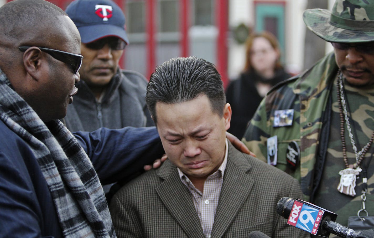 Kia Xiong, the father of two-year old shooting victim Neegnco Xiong, is comforted by Rev. Harding Smith of the Spiritual Church of God, left, and peace activist K.G. Wilson, right, as Xiong fought back tears while remembering his son during a vigil near the family's Cedar-Riverside area residence Saturday, Dec. 8, 2012, in Minneapolis, MN.] (DAVID JOLES/STARTRIBUNE) djoles@startribune.com) A vigil was held for two-year old shooting victim Neegnco Xiong near the family's Cedar-Riverside area resi