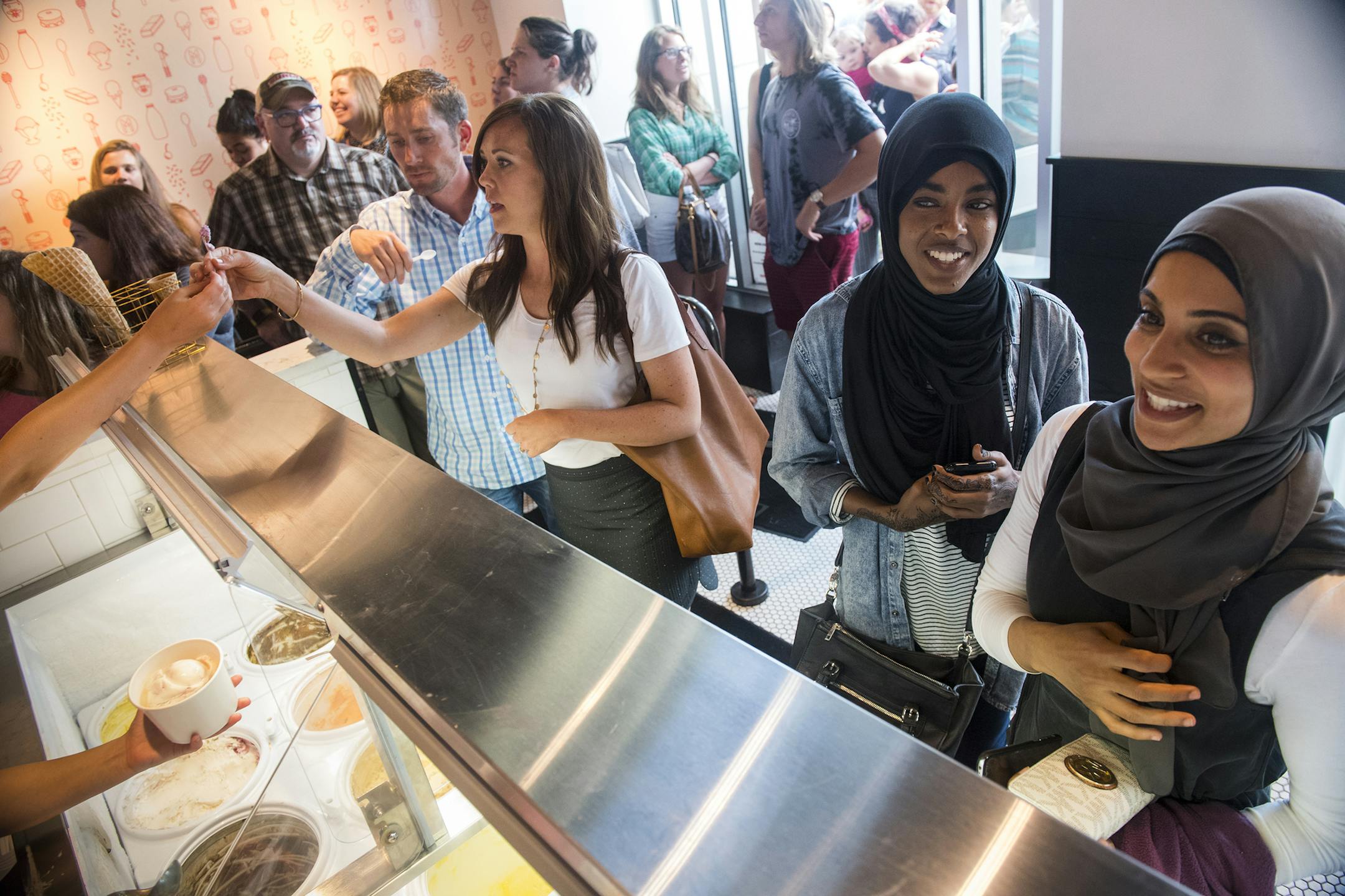 From left, Jon and Sara O' Brien sample ice cream flavors as Salma Hassan and Nancy Mahdy waited for their ice cream orders at Milkjam on Thursday. ] Isaac Hale ï isaac.hale@startribune.com Milkjam, located at 2743 Lyndale Ave S and run by Saffron chef Sameh Wadi, draws so many people that there's frequently a line out the door. Crowds came for ice cream on Thursday, July 7, 2016.
