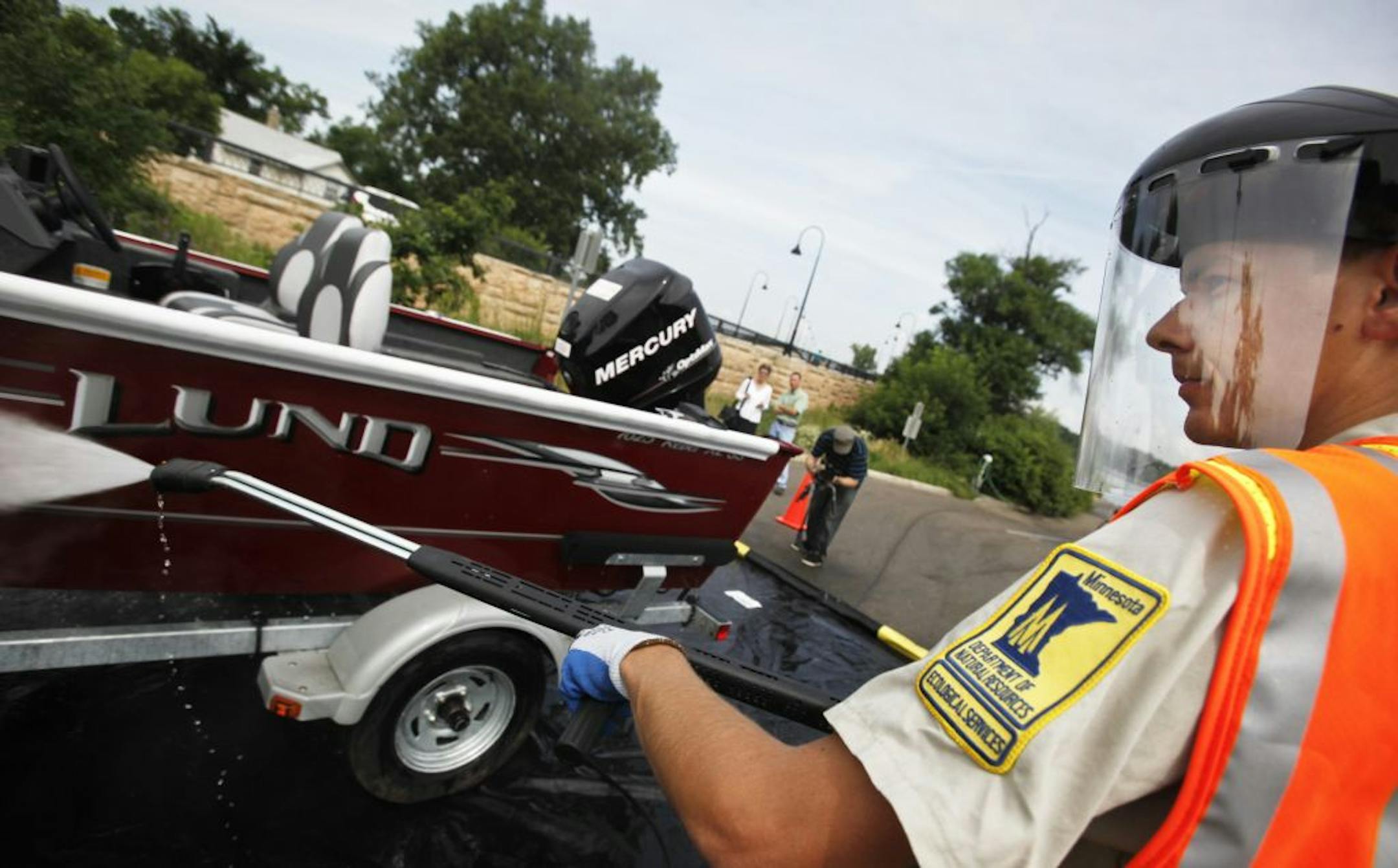 Adam Doll, a Minnesota Department of Natural Resources invasive species assistant, used a hot-water, high-pressure washer to demonstrate on a DNR boat a new decontamination effort the DNR will use at public accesses on high-traffic state lakes in an effort to prevent the spread of zebra mussels and other aquatic invasive species.