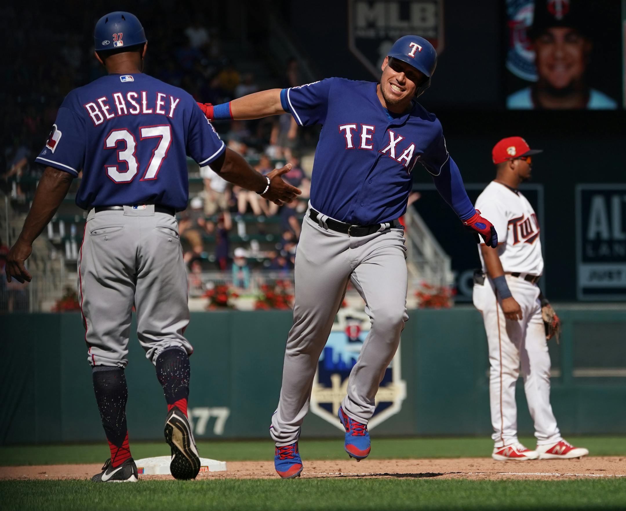 Rangers Joey Gallo(13) rounds 3rd base on a Rougned Odor(12) 3-run HR and slaps 3rd base coach Tony Beasley's hand.] At Target Field, the Twins take on the Texas Rangers on 7/7/19. RICHARD TSONG-TAATARII ¥ richard.tsong-taatarii@startribune.com