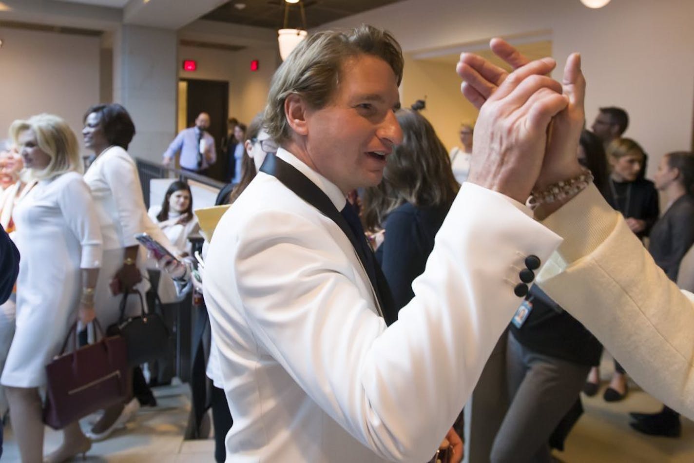 Rep. Dean Phillips, D-Minn., left, joins women by wearing white, after they posed for a group photo before the State of the Union address by President Donald Trump, on Capitol Hill, Tuesday, Feb. 5, 2019 in Washington.