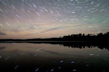 Stars are reflected in Elbow Lake Wednesday, Sep. 28, 2022 on the Gunflint Trail in Grand Marais, Minn. To make this image, a ten-minute exposure was 