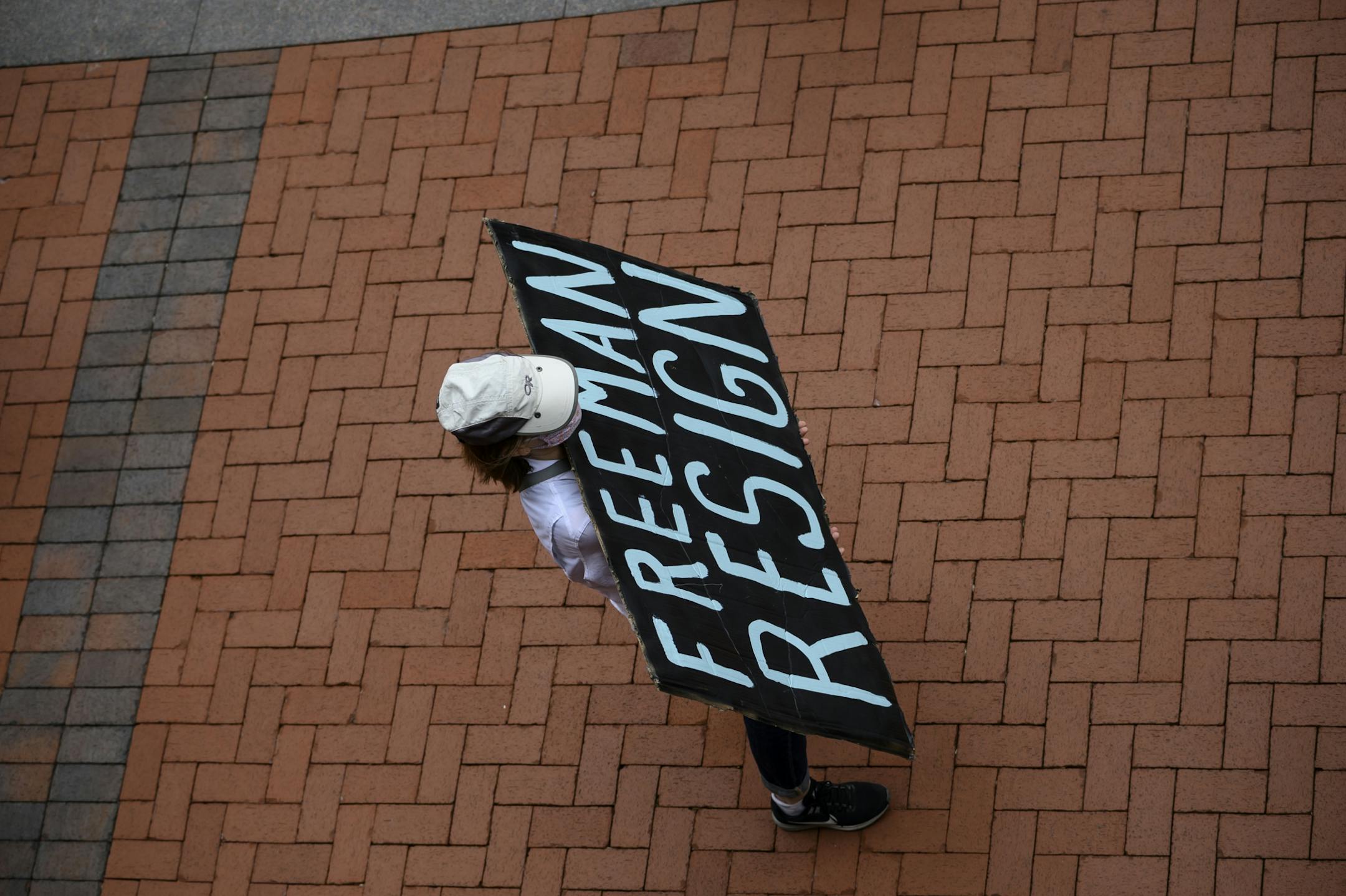 A protester held a "Freeman Resign" sign outside the Hennepin County Government Center Saturday.