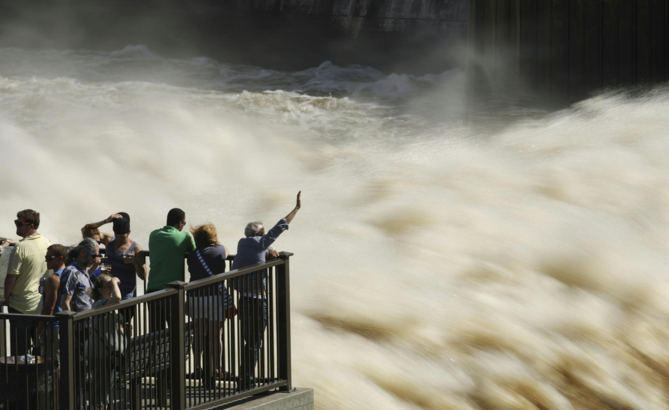 A steady crowd gathered to view the turbulant water flow at St. Anthony Falls from the observation platform at Water Power Park Sunday afternoon.