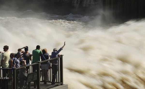 A steady crowd gathered to view the turbulant water flow at St. Anthony Falls from the observation platform at Water Power Park Sunday afternoon.