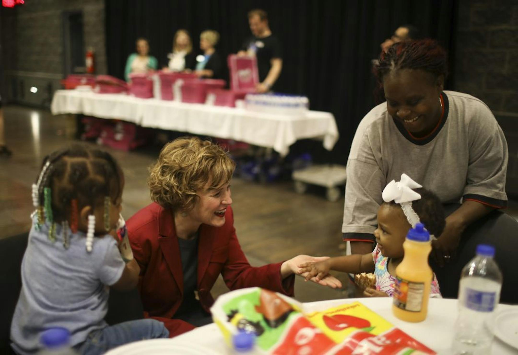 Mayor Betsy Hodges said hello to Makia Johnson, who was brought to the event by her grandmother, Tameca Johnson, right.