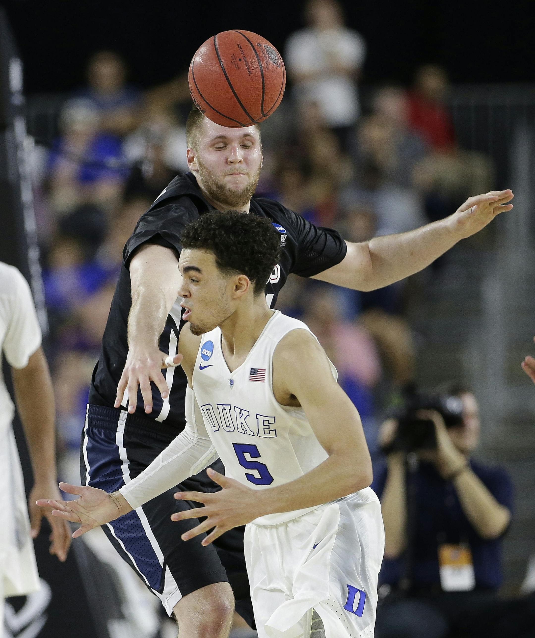 Gonzaga's Przemek Karnowski knocks the ball away from Duke's Tyus Jones (5) during the second half of a college basketball regional final game in the NCAA Tournament Sunday, March 29, 2015, in Houston. (AP Photo/Charlie Riedel)
