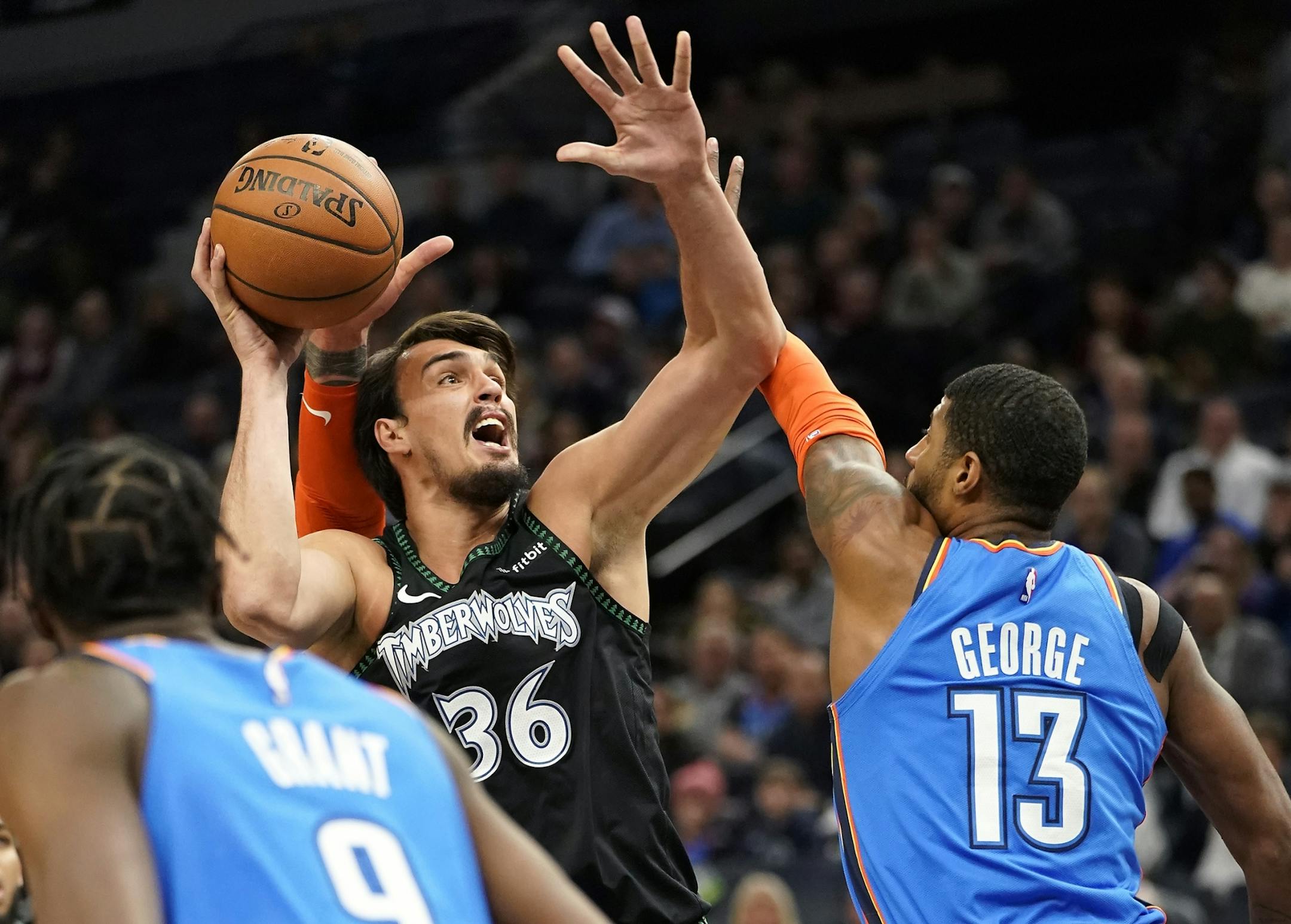 Minnesota Timberwolves forward Dario Saric (36) shoots as Oklahoma City Thunder forward Paul George (13) defends during the first half.