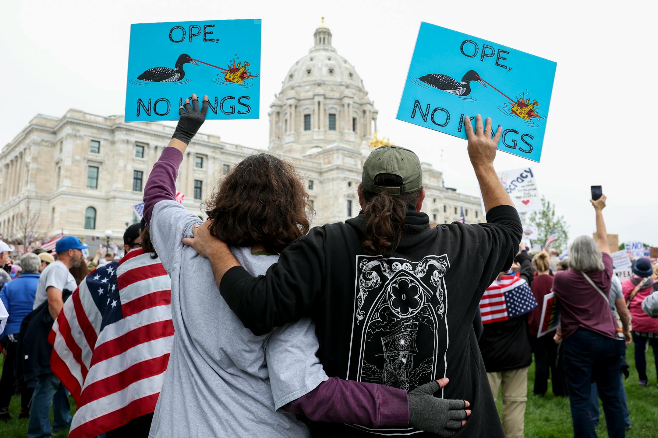 A couple embraces while protesting against the Trump administration during the No Kings protest outside the Minnesota State Capitol on Saturday, June 14, 2025, in St. Paul.