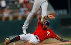 Left fielder Eddie Rosario(20) slides into third and scores on a throwing error in the seventh inning.