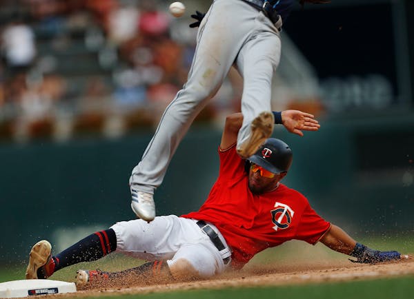 Left fielder Eddie Rosario(20) slides into third and scores on a throwing error in the seventh inning.